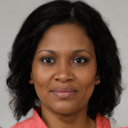 Joyful black adult female with medium  brown hair and brown eyes