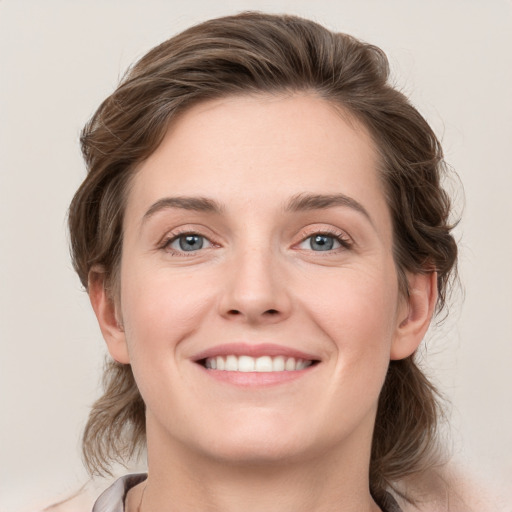 Joyful white young-adult female with medium  brown hair and grey eyes