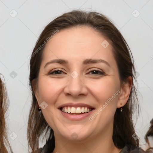 Joyful white adult female with long  brown hair and brown eyes