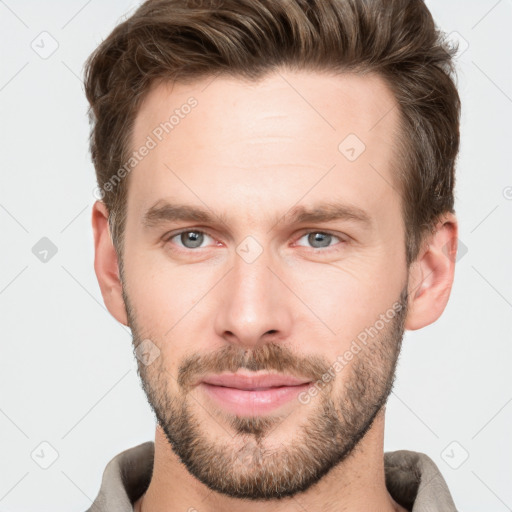 Joyful white young-adult male with short  brown hair and grey eyes