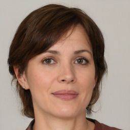 Joyful white adult female with medium  brown hair and brown eyes