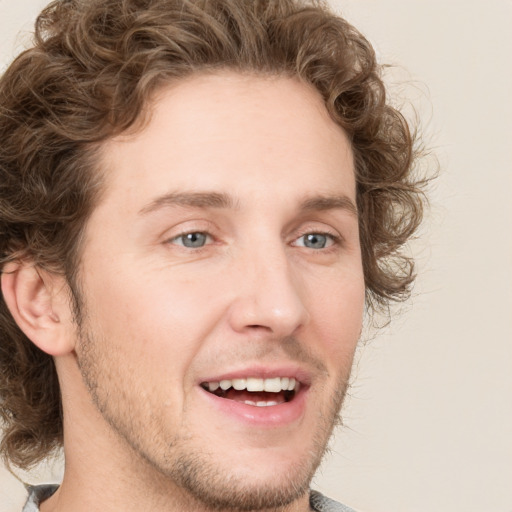 Joyful white young-adult male with medium  brown hair and grey eyes