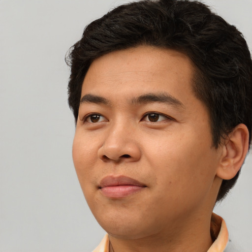 Joyful asian young-adult male with short  brown hair and brown eyes