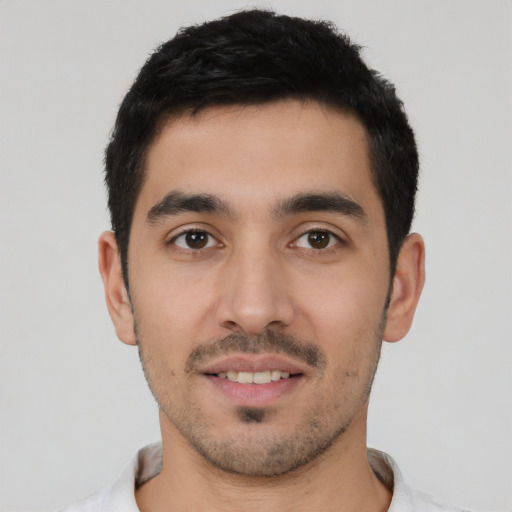 Joyful white young-adult male with short  black hair and brown eyes