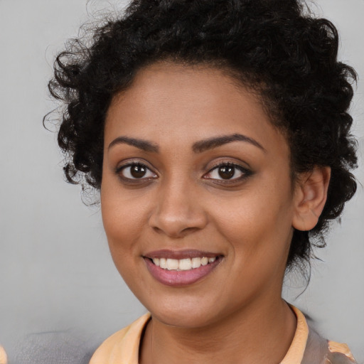 Joyful black young-adult female with long  brown hair and brown eyes
