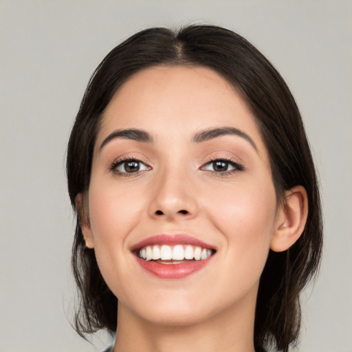 Joyful white young-adult female with medium  black hair and brown eyes