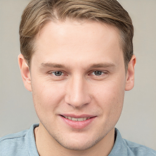 Joyful white young-adult male with short  brown hair and grey eyes