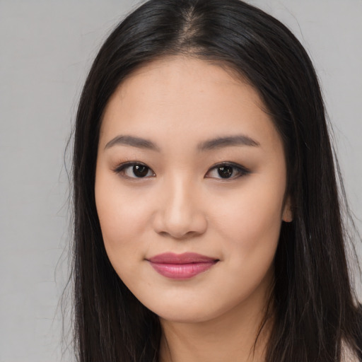 Joyful asian young-adult female with long  brown hair and brown eyes