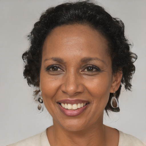Joyful black adult female with medium  brown hair and brown eyes