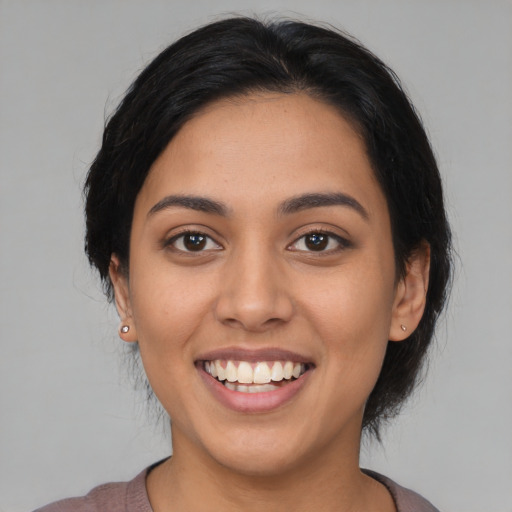 Joyful latino young-adult female with medium  black hair and brown eyes