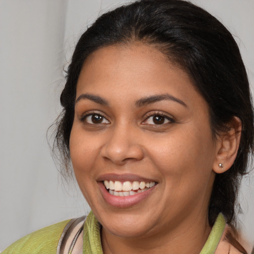 Joyful latino young-adult female with medium  brown hair and brown eyes