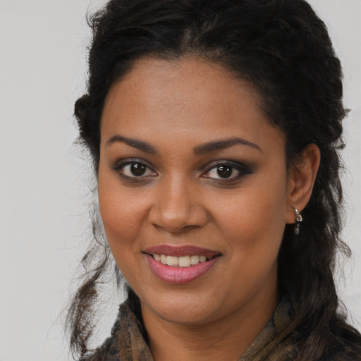 Joyful black young-adult female with long  brown hair and brown eyes