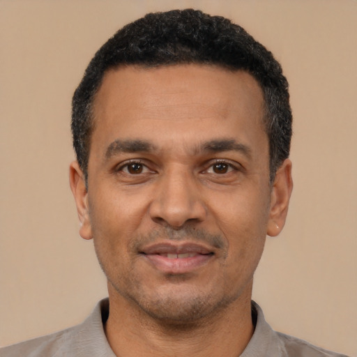 Joyful latino adult male with short  black hair and brown eyes