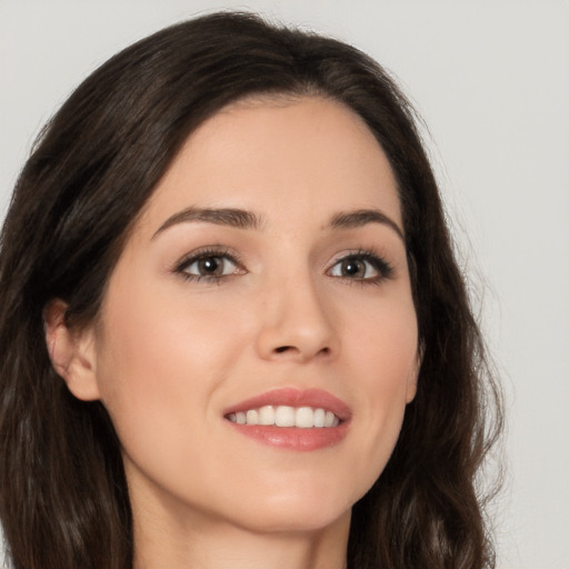 Joyful white young-adult female with long  brown hair and brown eyes