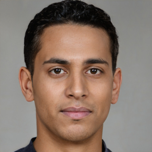 Joyful latino young-adult male with short  brown hair and brown eyes