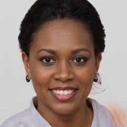 Joyful black young-adult female with short  brown hair and brown eyes