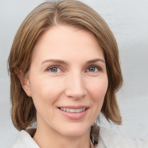 Joyful white adult female with medium  brown hair and grey eyes