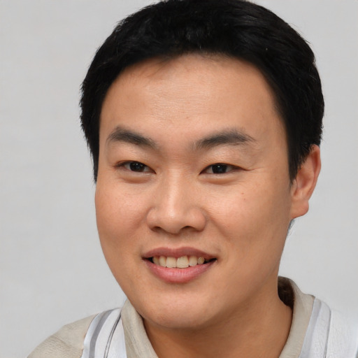 Joyful asian young-adult male with short  black hair and brown eyes