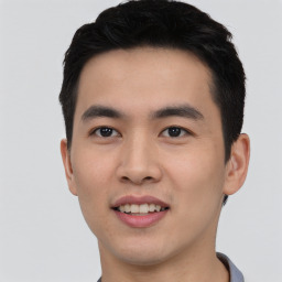 Joyful asian young-adult male with short  black hair and brown eyes