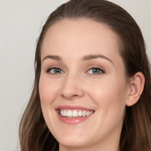 Joyful white young-adult female with long  brown hair and grey eyes