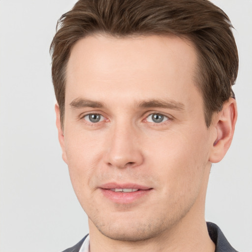 Joyful white young-adult male with short  brown hair and grey eyes