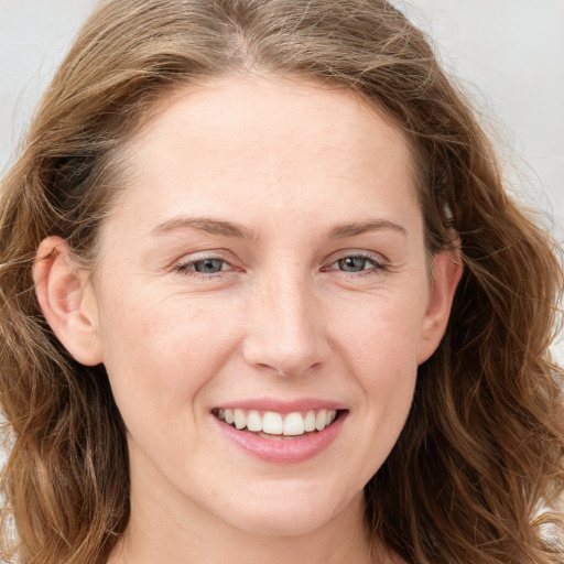 Joyful white young-adult female with long  brown hair and blue eyes