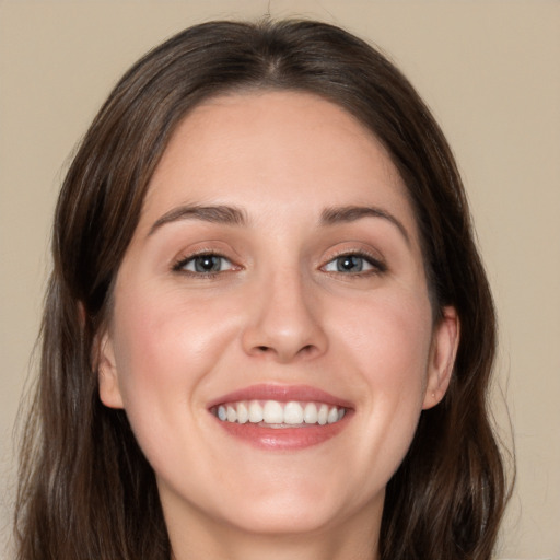 Joyful white young-adult female with long  brown hair and blue eyes