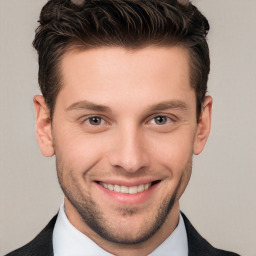 Joyful white young-adult male with short  brown hair and grey eyes