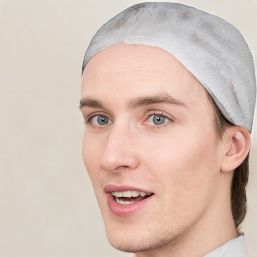 Joyful white young-adult male with short  brown hair and blue eyes