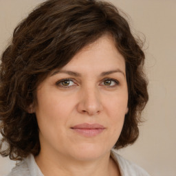 Joyful white young-adult female with medium  brown hair and green eyes