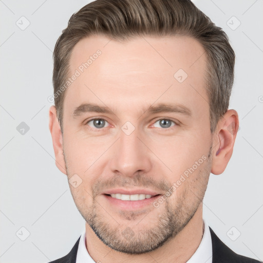 Joyful white young-adult male with short  brown hair and grey eyes