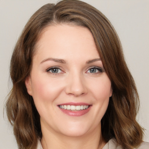 Joyful white young-adult female with medium  brown hair and grey eyes