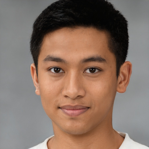 Joyful latino young-adult male with short  brown hair and brown eyes