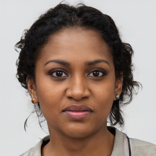 Joyful black young-adult female with short  brown hair and brown eyes