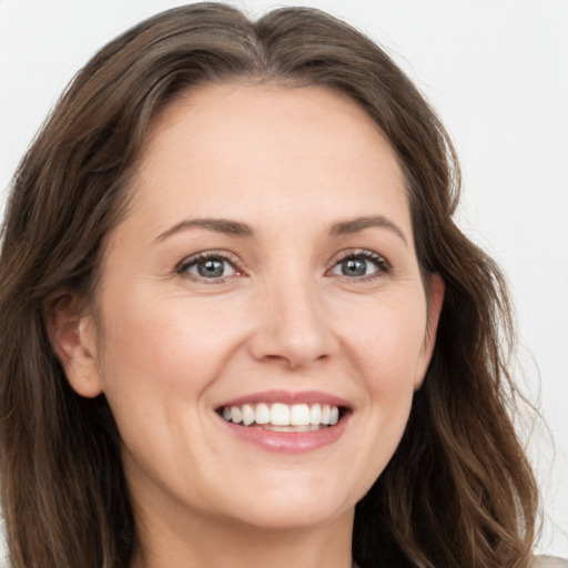 Joyful white young-adult female with long  brown hair and grey eyes