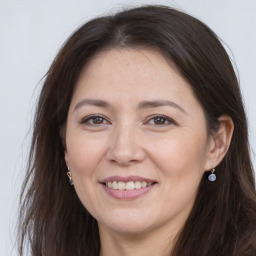 Joyful white adult female with long  brown hair and brown eyes