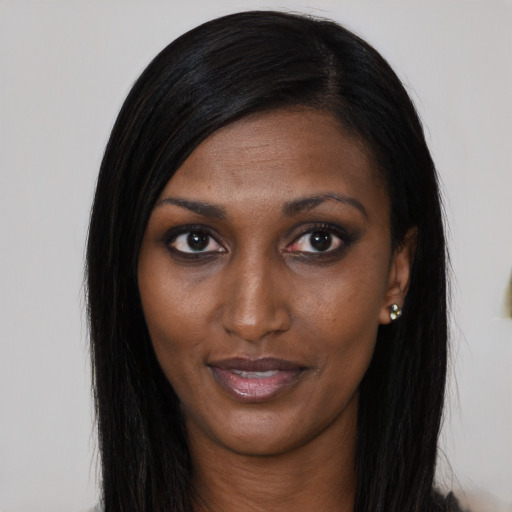 Joyful black young-adult female with long  black hair and brown eyes