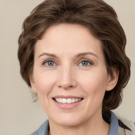 Joyful white adult female with medium  brown hair and grey eyes