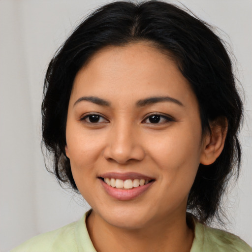 Joyful asian young-adult female with medium  black hair and brown eyes