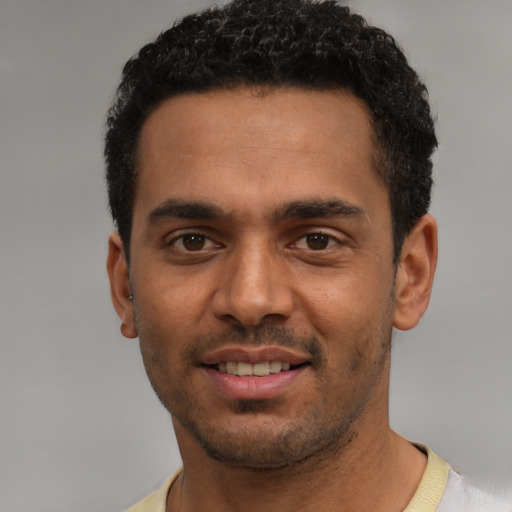 Joyful black young-adult male with short  black hair and brown eyes