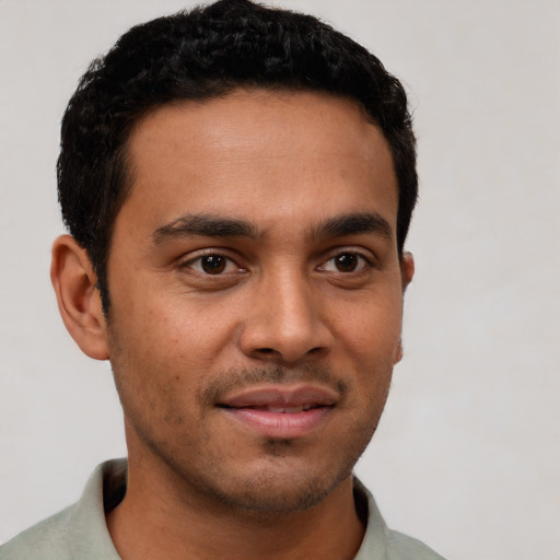 Joyful latino young-adult male with short  brown hair and brown eyes
