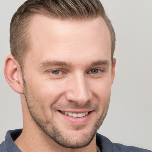 Joyful white young-adult male with short  brown hair and grey eyes