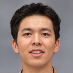 Joyful asian young-adult male with short  brown hair and brown eyes