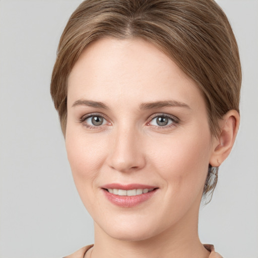 Joyful white young-adult female with medium  brown hair and grey eyes