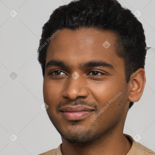 Joyful black young-adult male with short  black hair and brown eyes