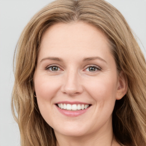 Joyful white young-adult female with long  brown hair and green eyes