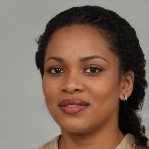 Joyful black young-adult female with long  brown hair and brown eyes