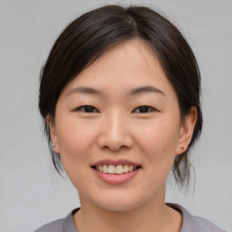 Joyful asian young-adult female with medium  brown hair and brown eyes