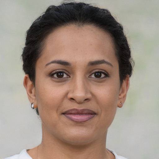 Joyful latino adult female with short  brown hair and brown eyes