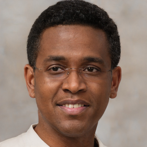 Joyful black young-adult male with short  brown hair and brown eyes